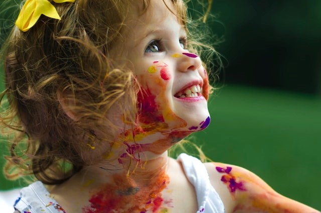 Pomalowana farbkami mała dziewczynka